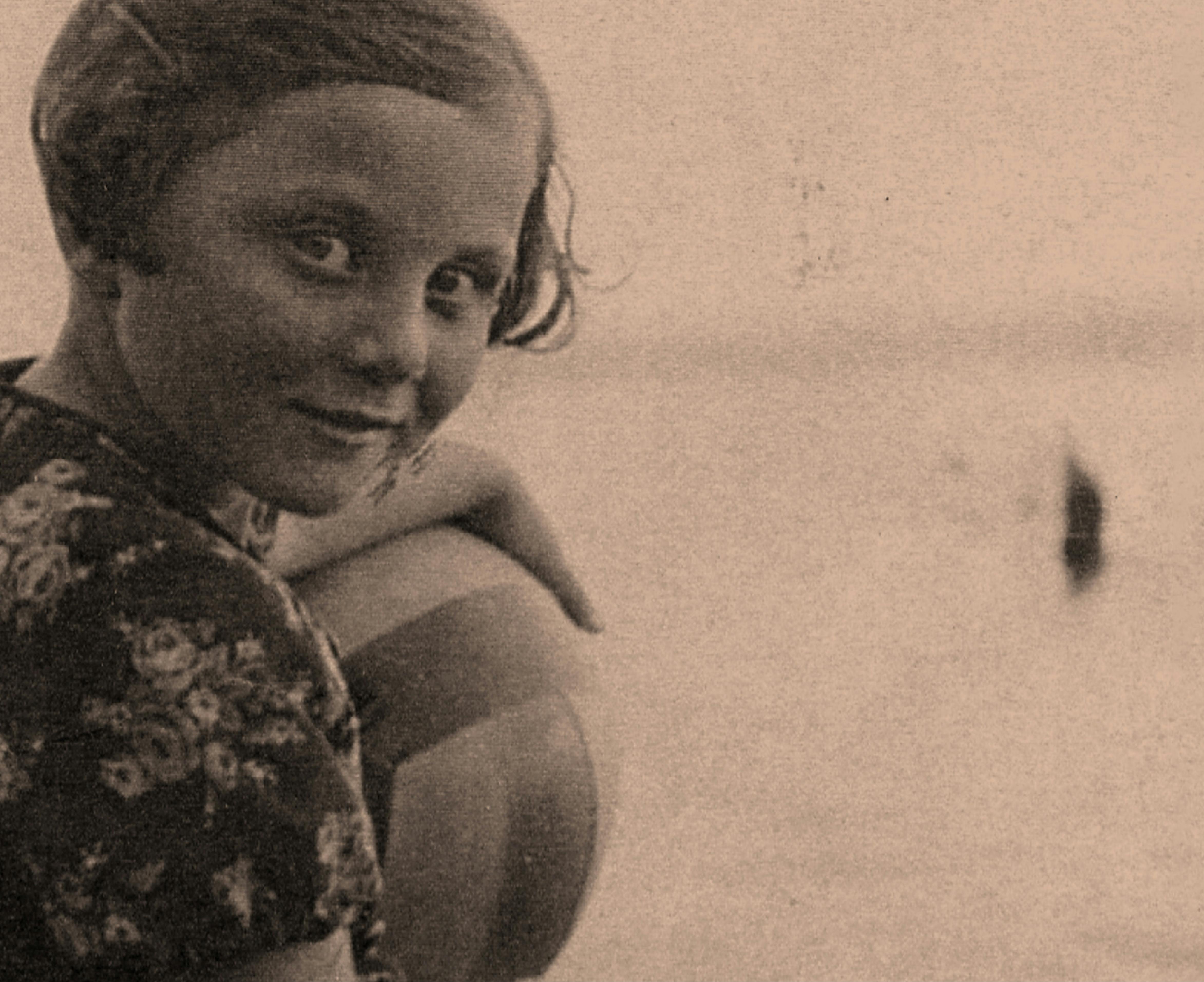 Trude as a child holding a beach ball.